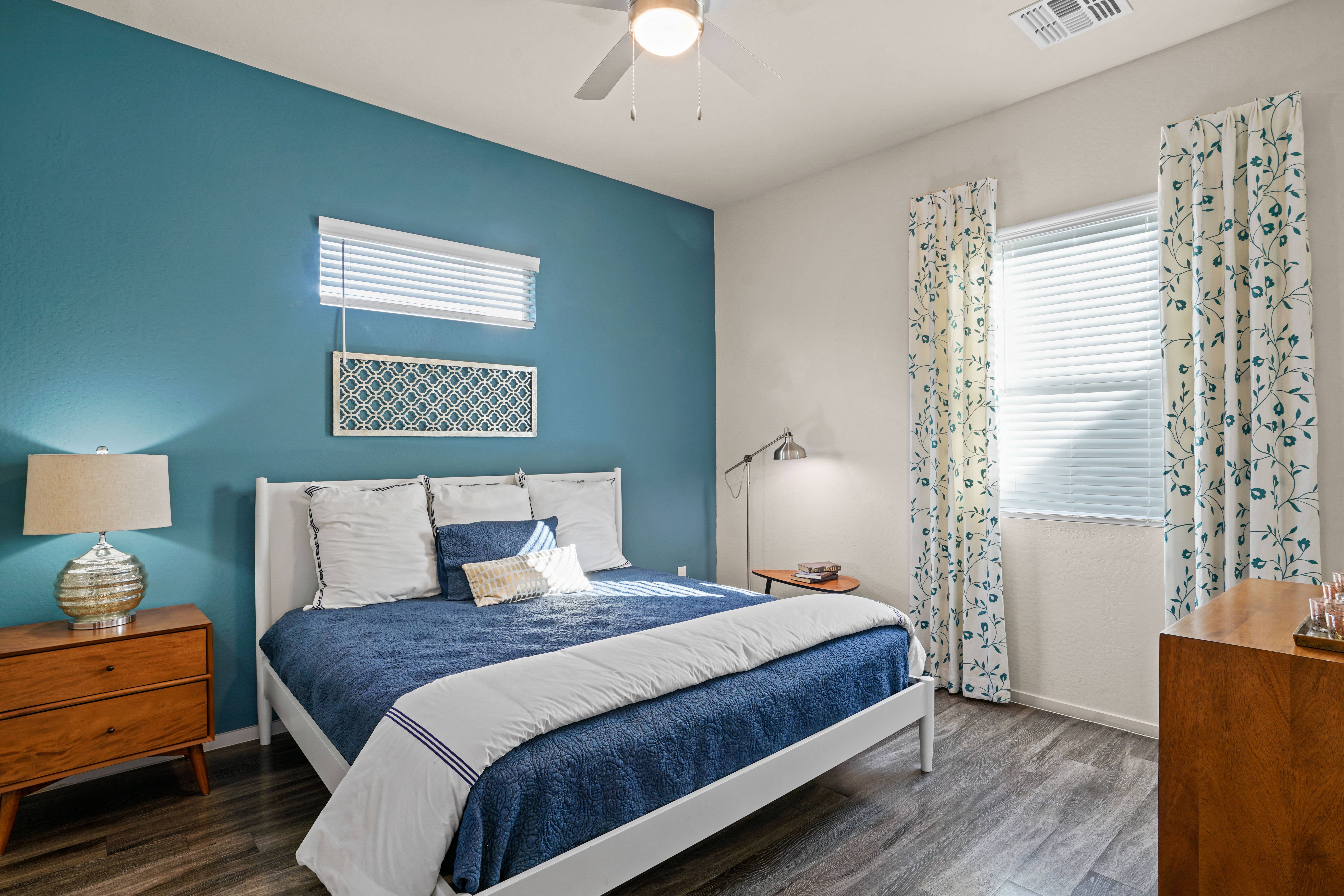 a blue and white bedroom with a bed and a ceiling fan at Olive Queen Creek Apartments, Arizona, 85142